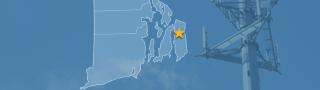 The state of Rhode Island, with outlined county borders and a star locating Tiverton, Rhode Island; a cell tower.