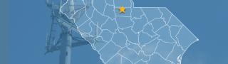 The state of South Carolina, with outlined county borders and star locating Chester, South Carolina; a cell tower.