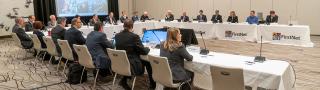 FirstNet Authority Board members sit at tables facing each other during a Board meeting 