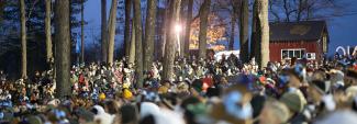 A group of people gathered in a wooded area attending the annual Groundhog Day ceremony