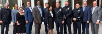 A group of FirstNet Authority, LAPD, and AT&T personnel posed in front of an LAPD office