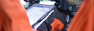 U.S. Coast Guard pilot using tablet, seated in cockpit