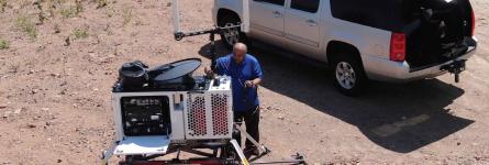 A man sets up a Compact Rapid Deployable for use in a desert area